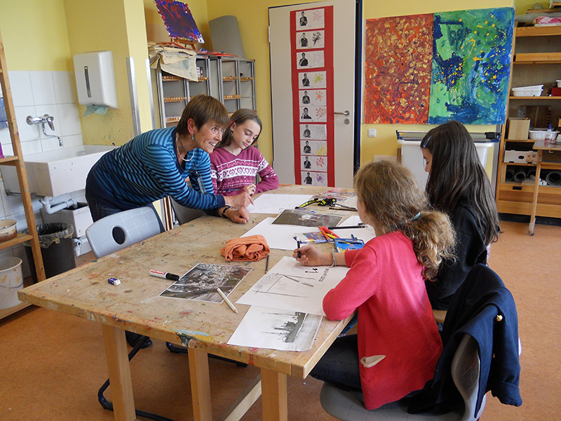 Die Illustratorin Marlis Kahlsdorf malt zusammen mit Schülerinnen und Schülern Bilder aus dem Alltag auf einem Fischdampfer